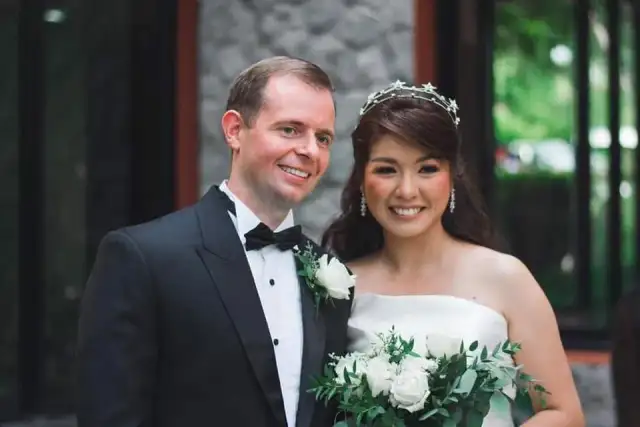 A bride and groom close together, the groom in black tie