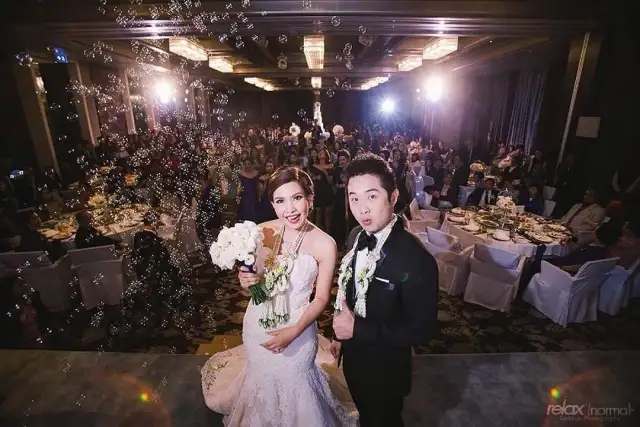 A bride and groom at their reception, the groom in black tie