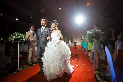 A bride walking a red carpet at an evening reception