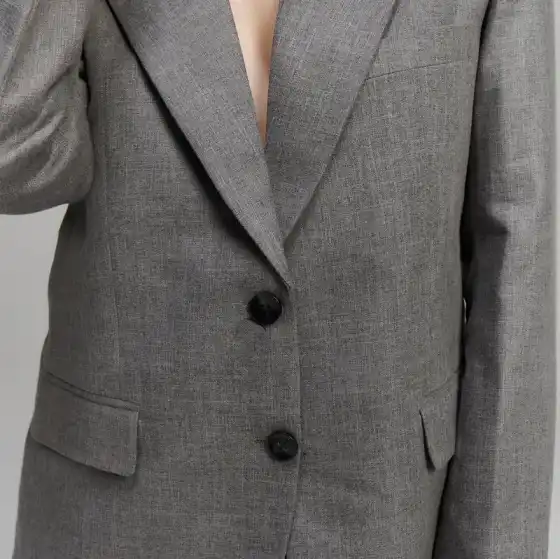 A grey two-button jacket, lapel and front edge in close view