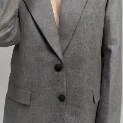 A grey two-button jacket, lapel and front edge in close view