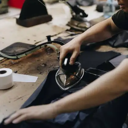 A jacket being pressed with an iron on the table