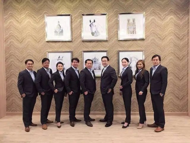 The Loft team lined up in navy suits in front of framed illustrations