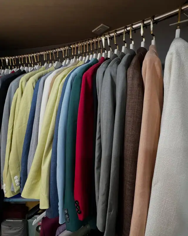 A long rail of jackets in many colours along the shop wall