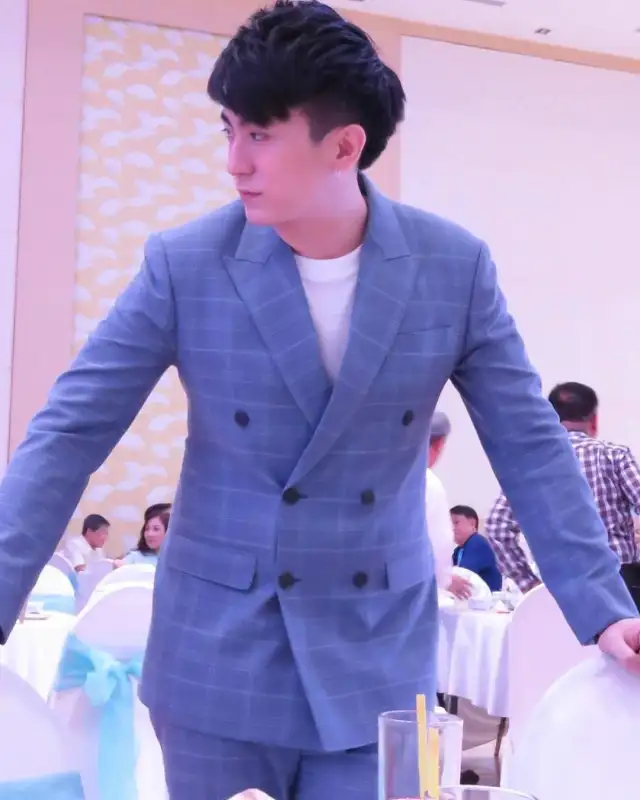 A man in a blue check double-breasted suit, jacket open