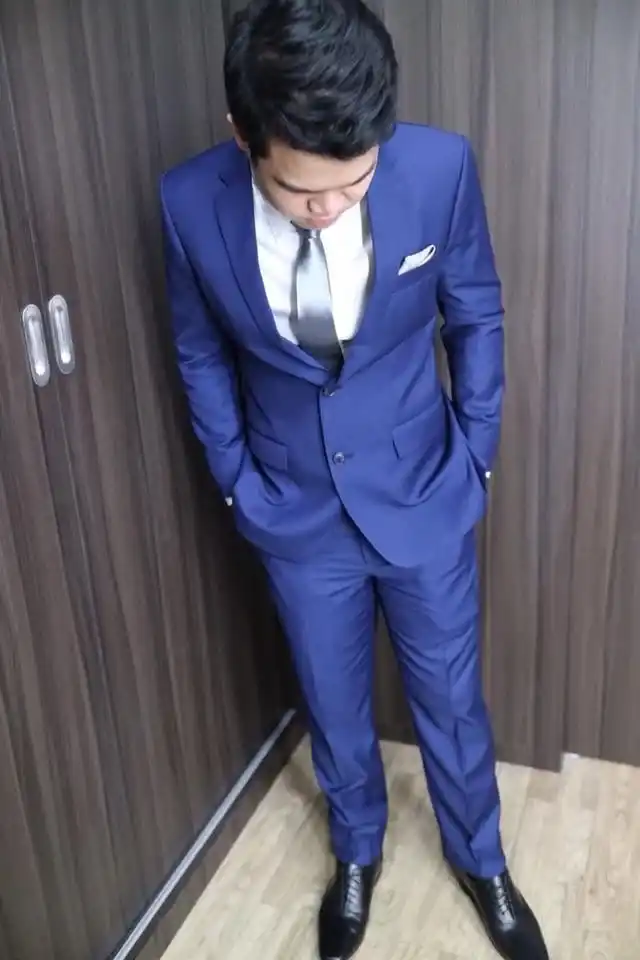 A man in a blue suit photographed from above, full length, shoes showing