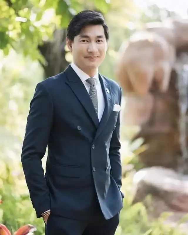 A man in a navy suit and tie standing outdoors