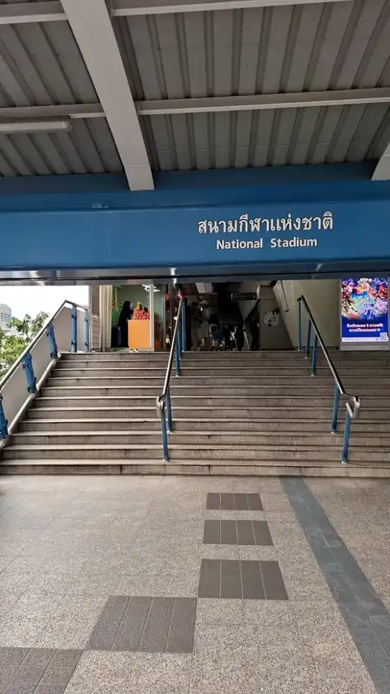 The National Stadium station entrance, a staircase beneath the blue station sign