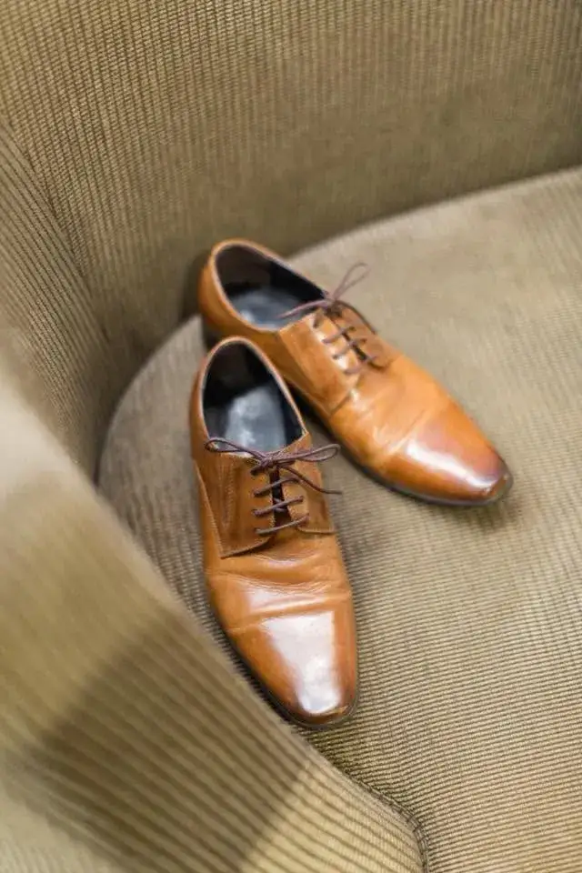 A pair of tan leather brogues resting on olive cloth