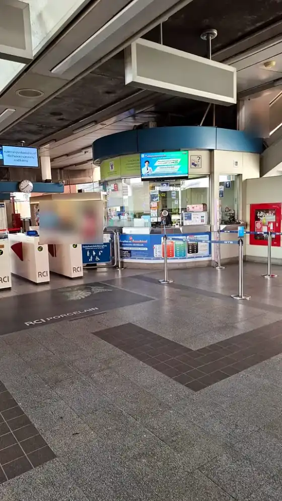 The station ticket hall, ticket gates on the left and the ticket office behind a queue barrier