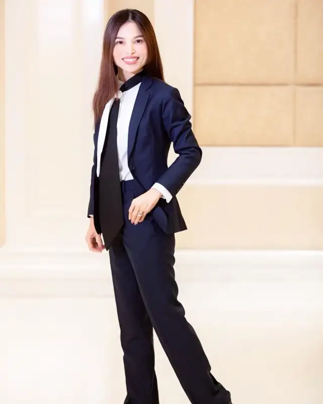 A woman in a navy trouser suit worn over a white shirt