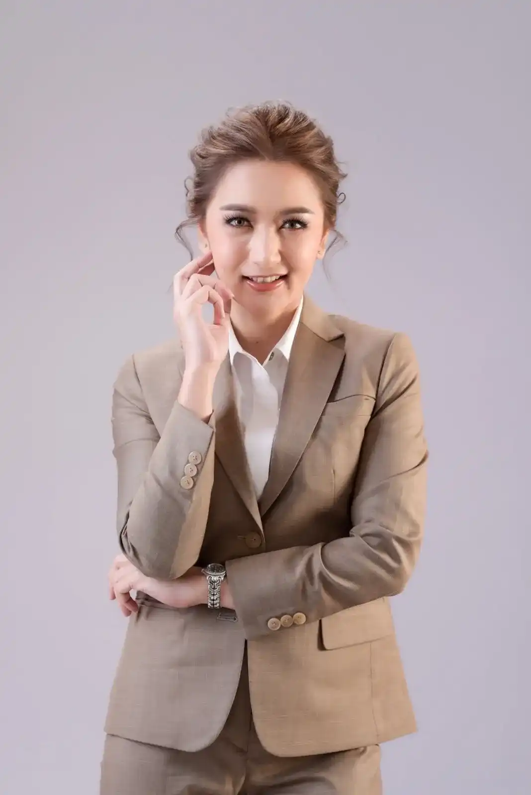 A woman in a tan single-breasted suit and white shirt