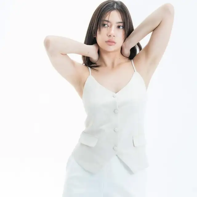 A woman in a white buttoned waistcoat