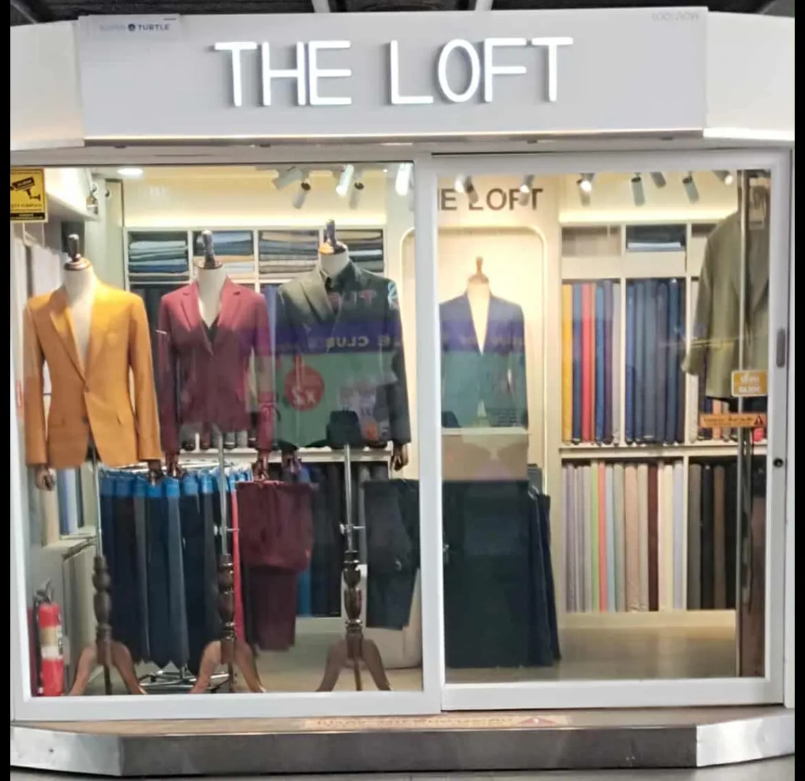 The Loft Tailors shopfront, with suits and jackets on mannequins behind the glass