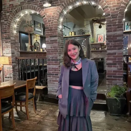 A woman wearing a grey tailored jacket